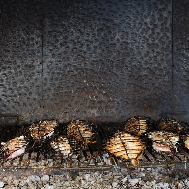 Batch of fish being roasted on the grill