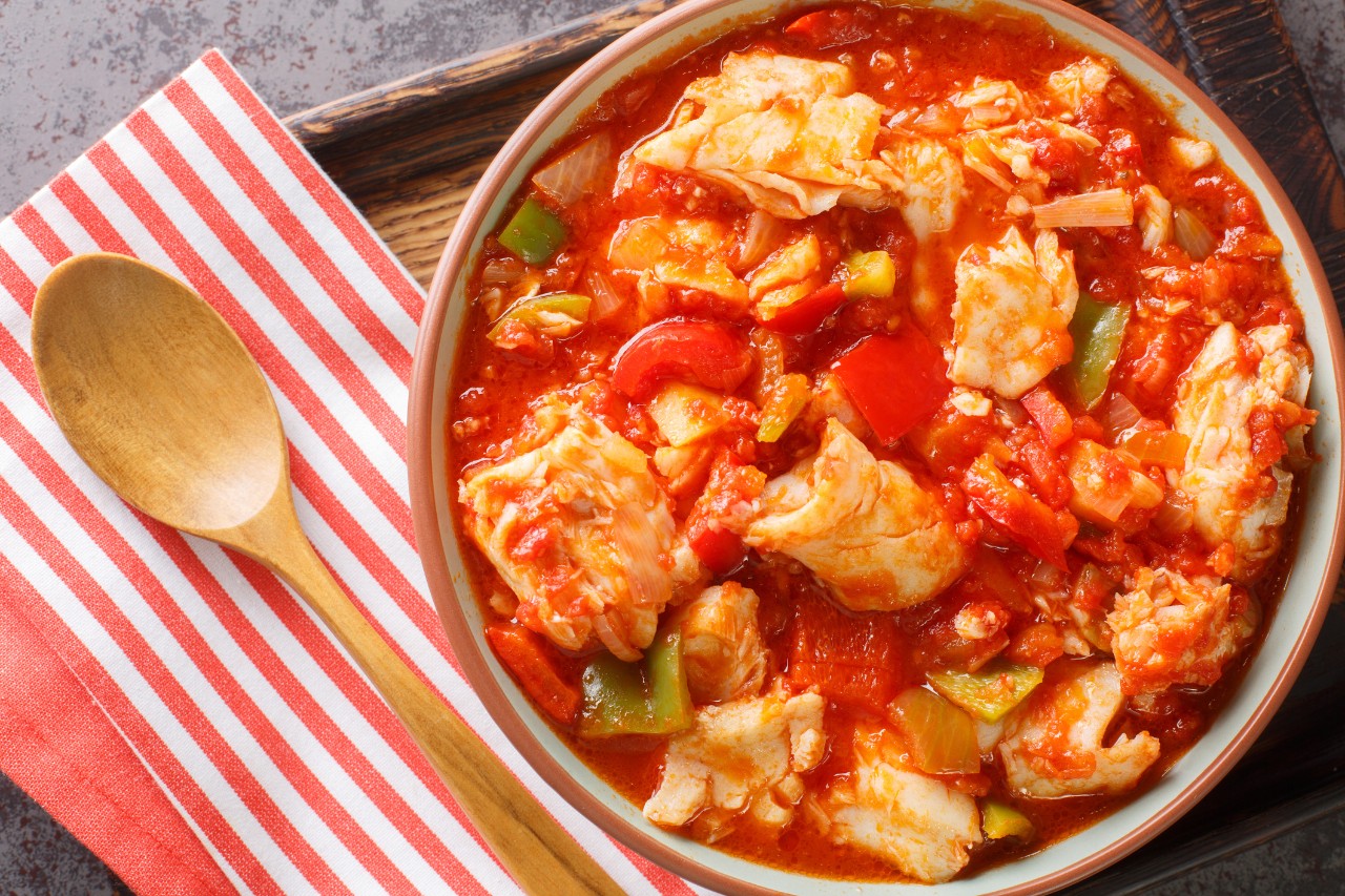 Bacalao al ajoarriero Cod with peppers and tomato sauce closeup on the bowl on the table. Horizontal top view from above