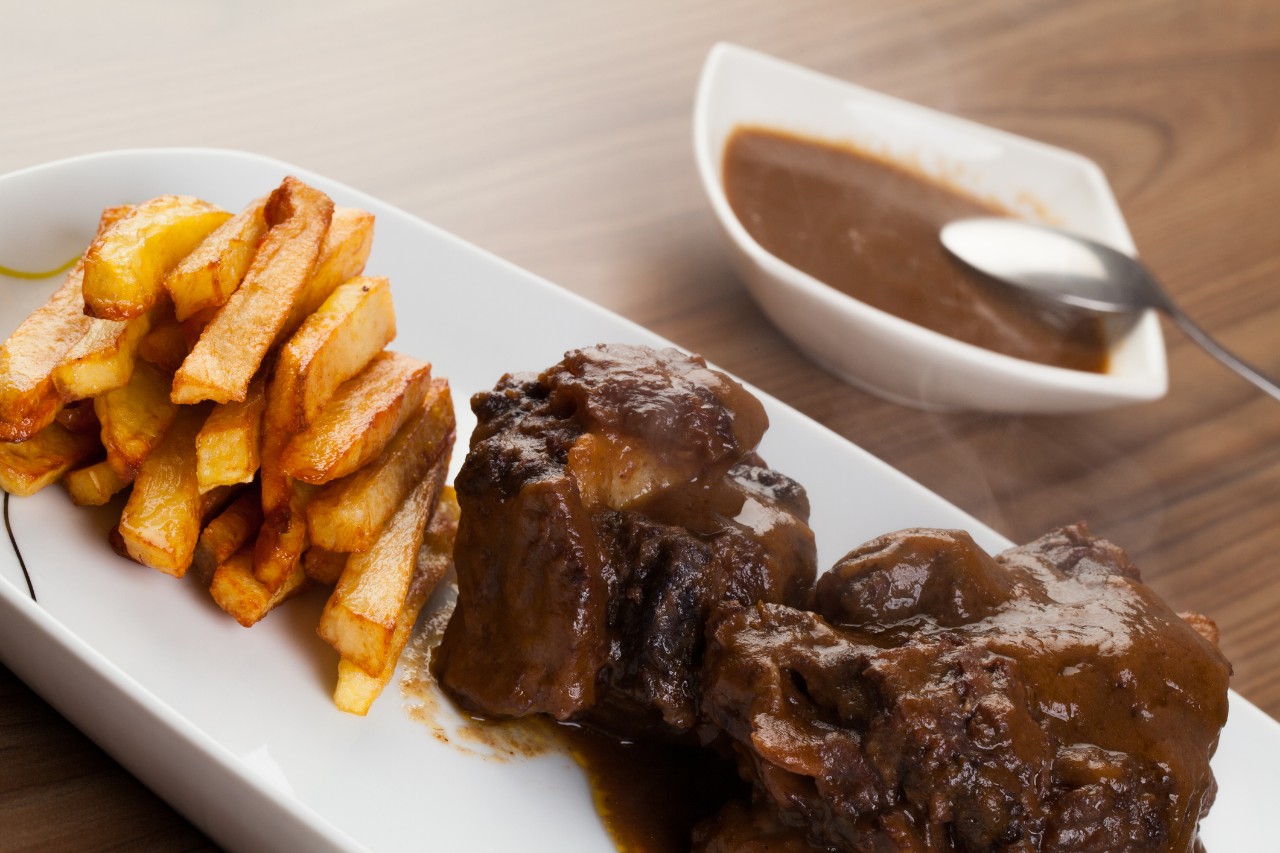 Spanish dish with bull tail and fried potatoes