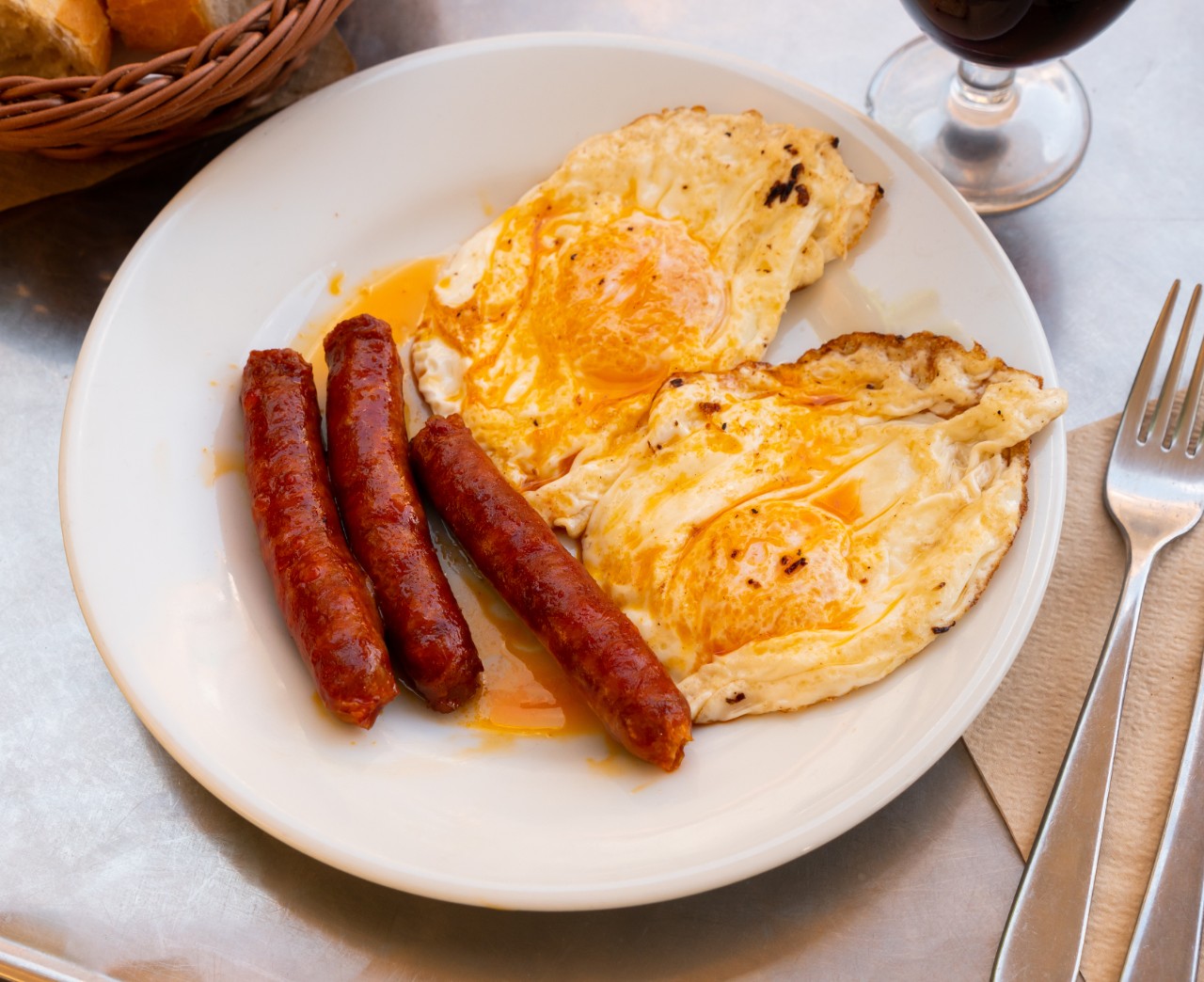 Just cooked fried eggs with chistorras served on table.