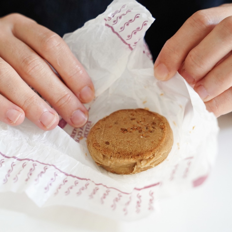Unrecognizable female wrapping polvoron in paper for celebrating Christmas