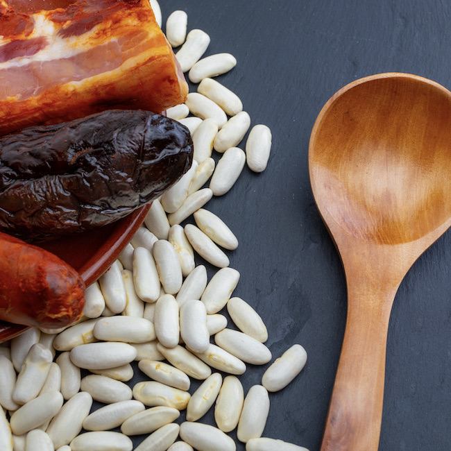 Appetizing spoon dish. Delicious for autumn, winter and all year. Asturian fabada, typical dish of Asturias (Spain). Stew of beans (white beans) with chorizo, bacon, black pudding, bacon, onion, garlic, parsley and salt.