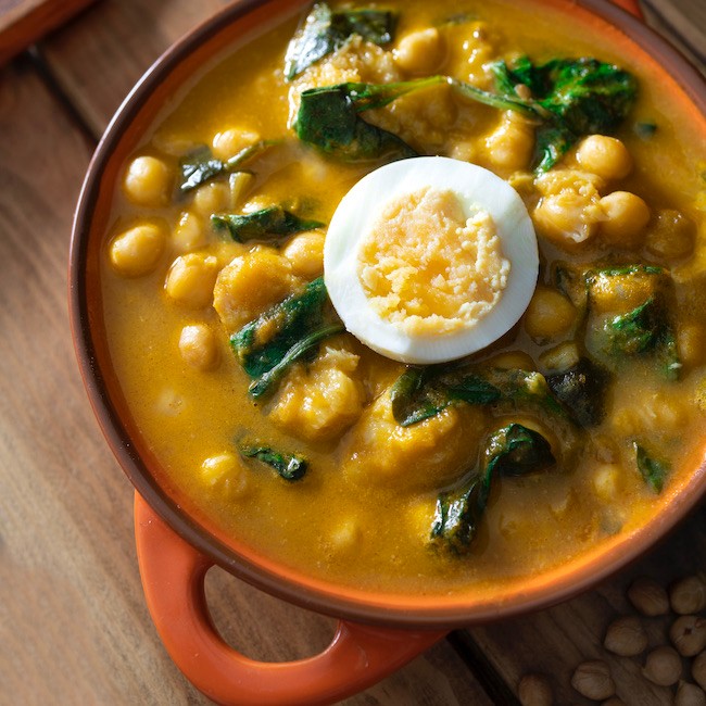 Traditional Spanish cuisine dish that is eaten mainly during the Holy Week holidays. Chickpea, cod, spinach and egg soup. Vigil Potaje. Food photography