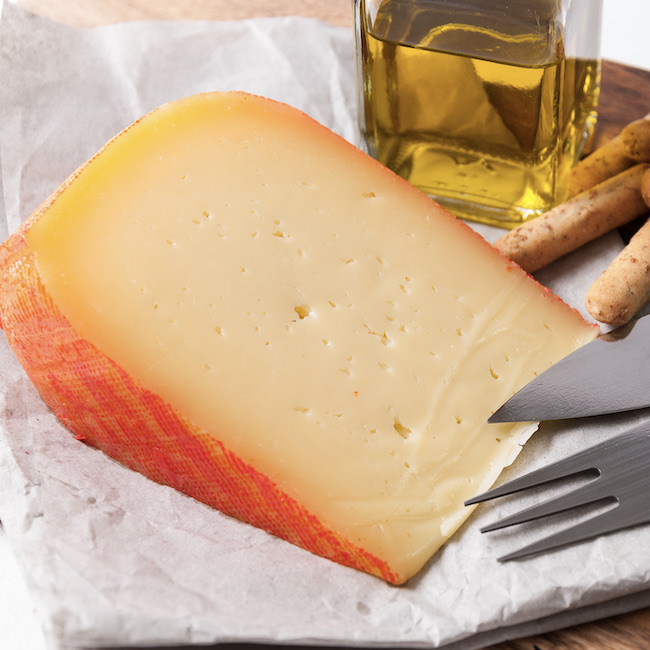 Cuña de queso con palitos de pan y aceite