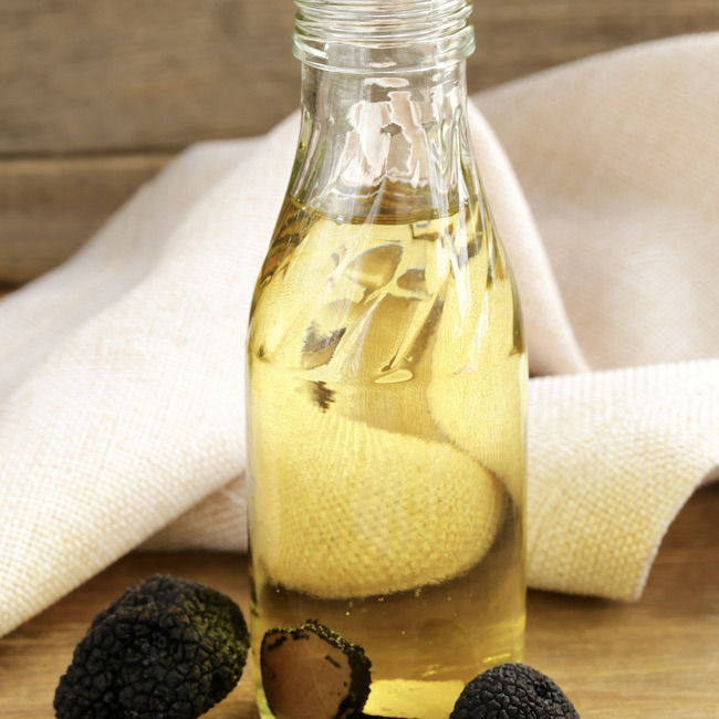 Olive oil flavored with black truffle on a wooden table