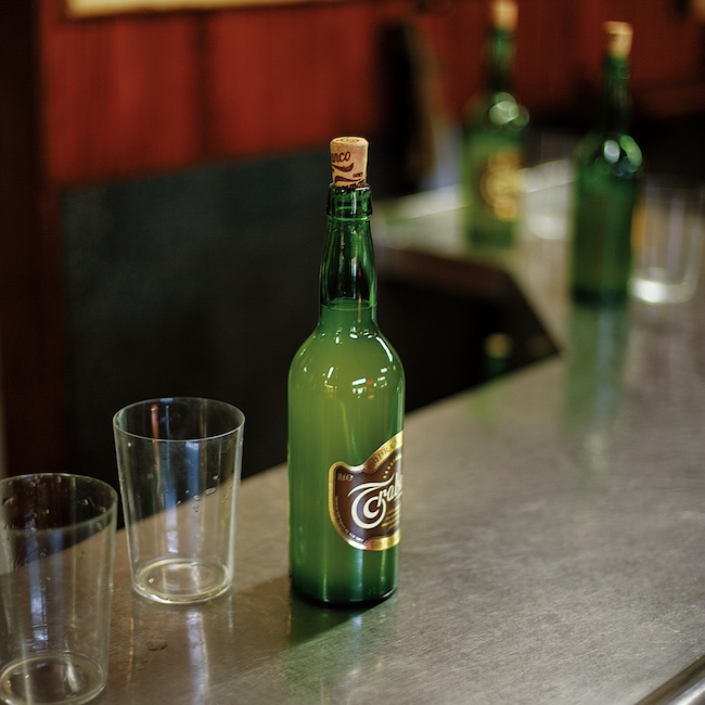 Detail of an Asturian cider bottle and two cider glasses on the bar of the restaurant/cider bar Casa Justo in GijÛn, Asturias