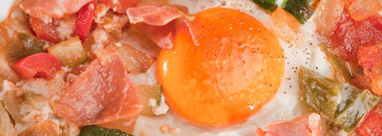 Spanish recipe: Baked eggs with Spanish vegetables and Serrano ham. Photo by: Toya Legido/©ICEX.