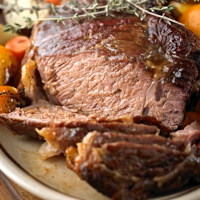 Close up of Roasted Beef with Bone and Vegetables.