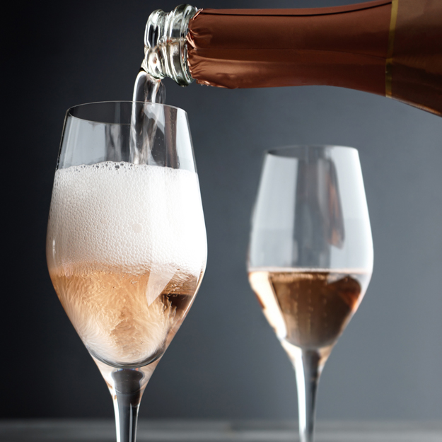 Rose Champagne / Pink Champagne being filled into Glass, selective focus